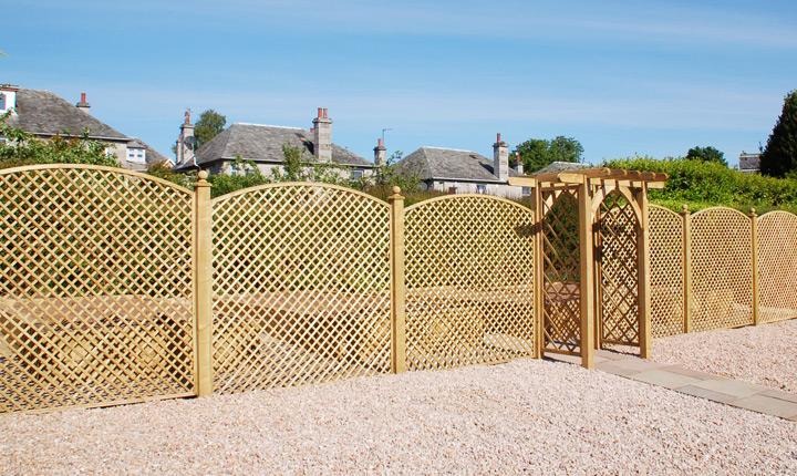 Diamond trellis fencing with a matching pergola gate over a gravel driveway