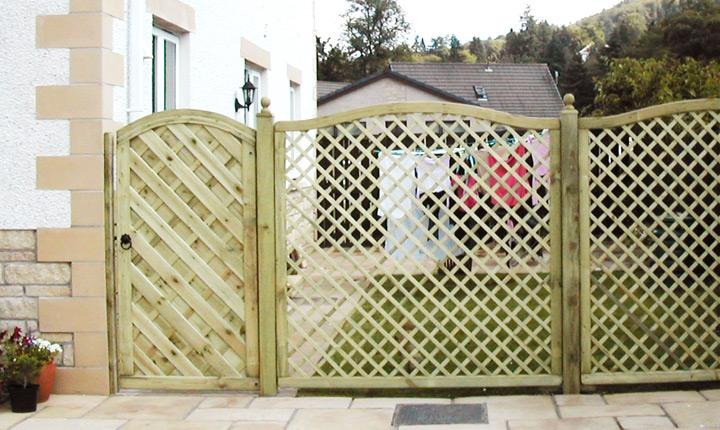 Trellis fencing and matching arched timber gate beside a house entrance